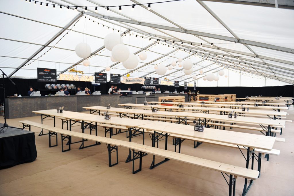Beer festival tables and benches in a clearspan marquee