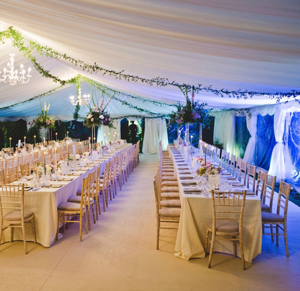 12m Clearspan marquee with ivory linings, hard flooring and beige carpet, with trestle tables and limewash chiavari chairs, built by Archers Marquees in Oxford