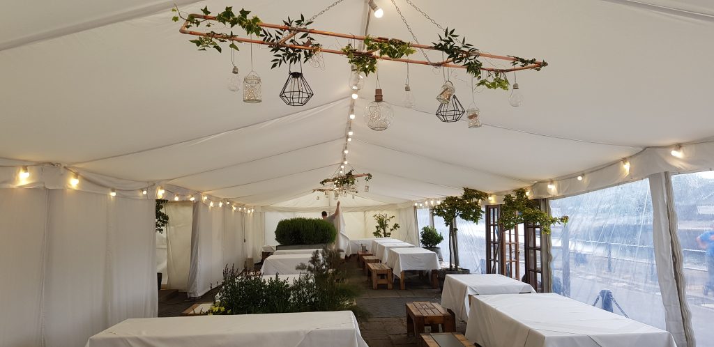 Flat white linings and festoon lighting in a clearspan marquee built by Archers Marquees in Bristol
