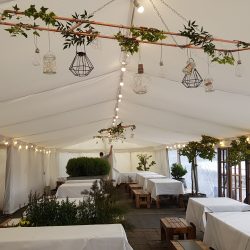 Flat white linings and festoon lighting in a clearspan marquee built by Archers Marquees in Bristol