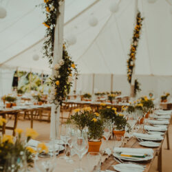 Sunflowers wrapped around the poles in a traditional marquee