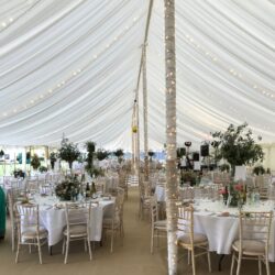 Fairylights wrapped around the pole in a traditional marquee